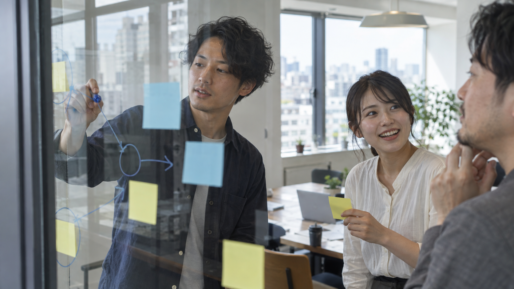 ガラス越しに、ボードへ書き込みながら考えを共有する人たち。